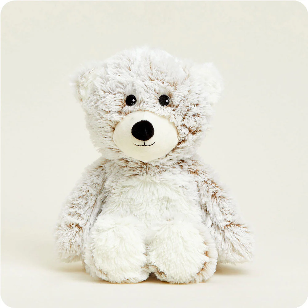 cream colored bear with long fur, white belly and muzzle, black nose and eyes