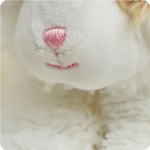 close up of longer body fur and shorter cream fur on face, pink embroidered nose and mouth