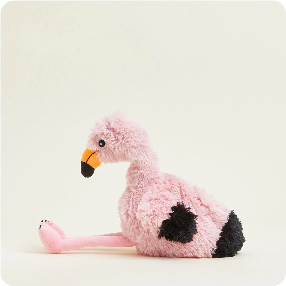 side view of flamingo sitting, shows black tipped wings and tail