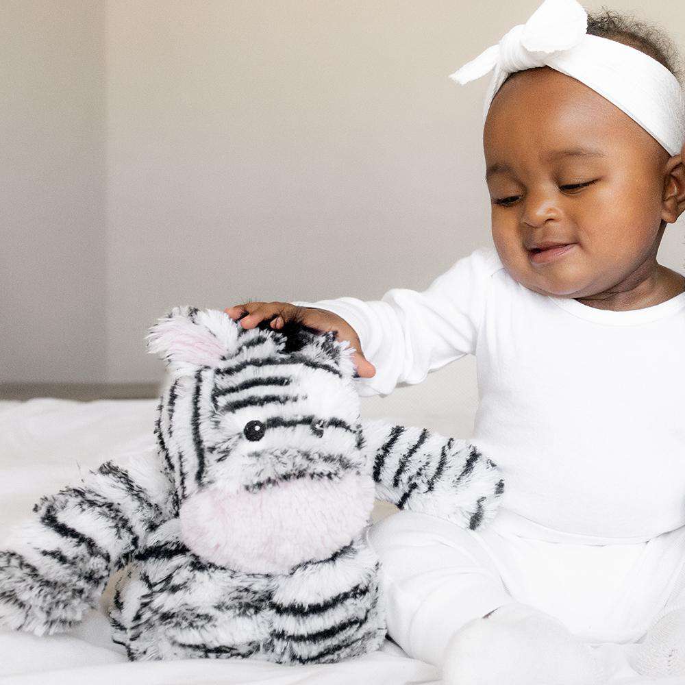 Zebra stuffie sitting with baby. Stuffie reaches shoulder height of sitting baby.