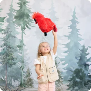lifestyle image of girl in explorer vest throwing cardinal up in the air