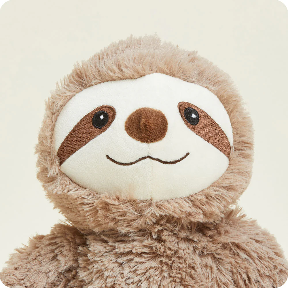 closeup of short cream fur face with embroidered brown eye patches, black eyes, black curved mouth and brown nose