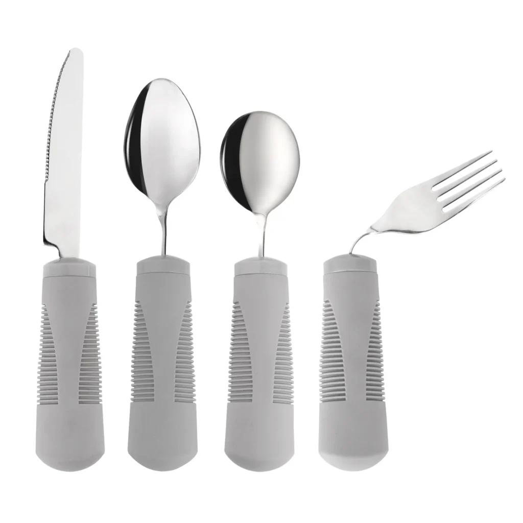 knife, 2 spoons and a fork with the tines bent to the right. all of them have chunky grey plastic handles
