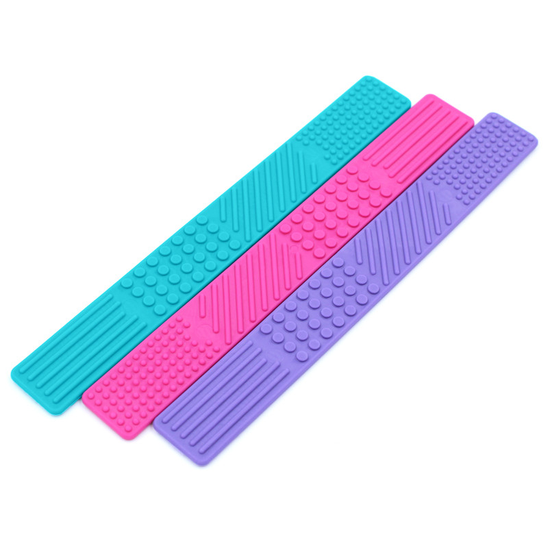 3 bookmark shaped fidgets with textures on the surface in teal, pink and purple