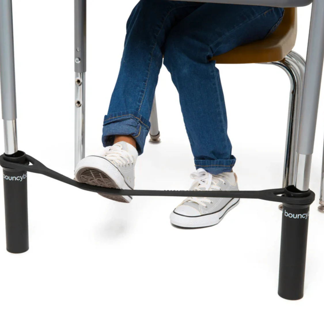 child in desk kicking the band between the two front desk legs