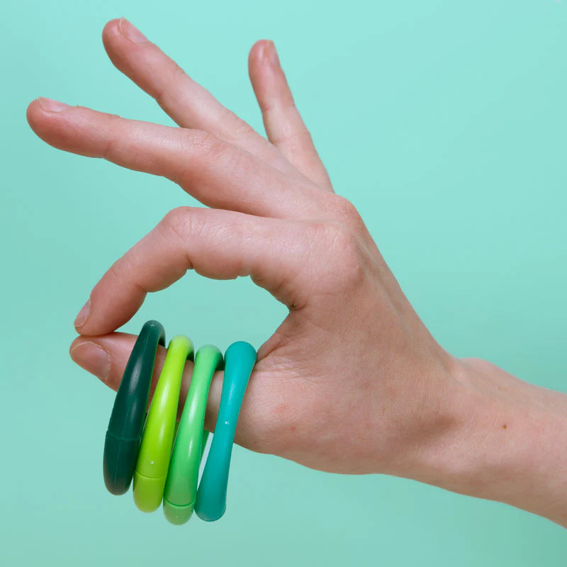 A magnetic fidget coil wrapped around a thumb