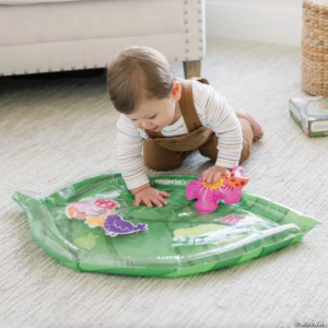 toddler playing with plastic mat shaped like a leaf with water inside