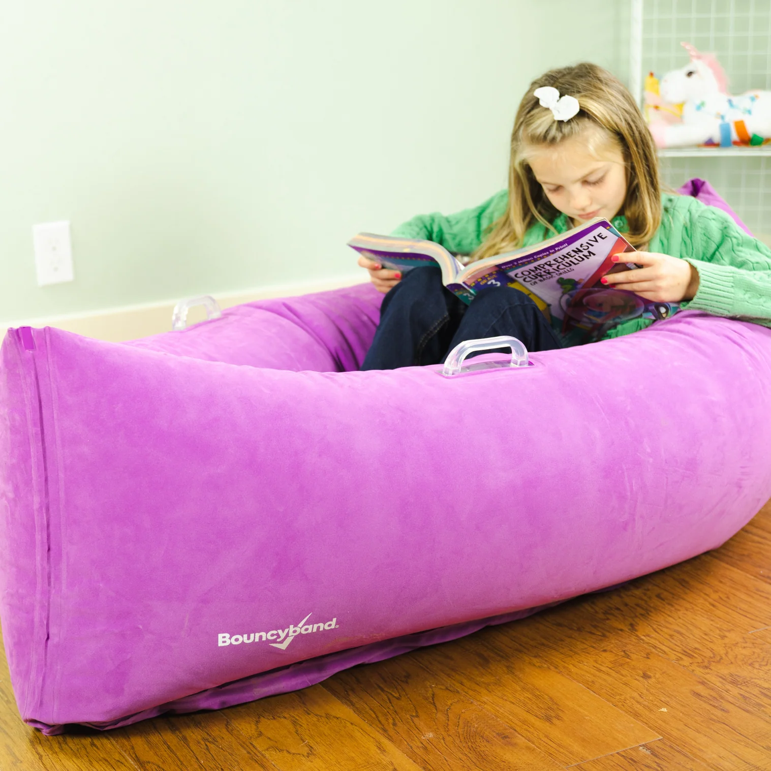 girl reading in canoe shaped chair that compresses her sitting in the middle
