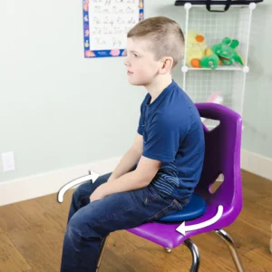 boy sitting on top of seat cushion on school chair, shows it can twist