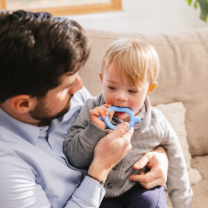 a man and toddler with a blue chew
