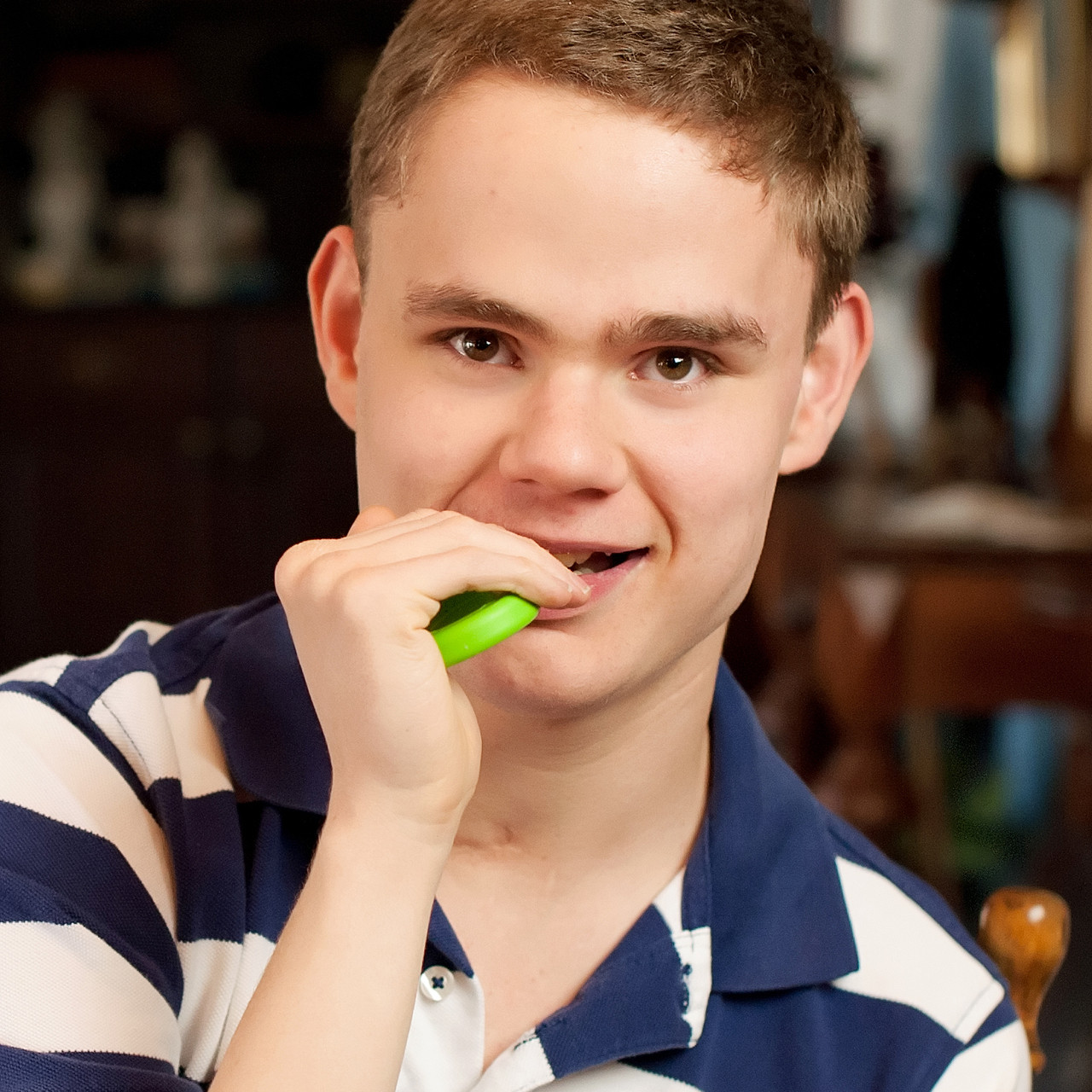 a teen boy chewing a green chew