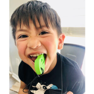 young child chewing on green dino necklace chew