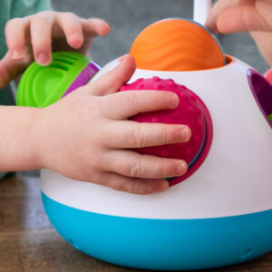 small hands grasp the multi-textured balls in different colors