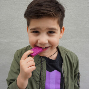 young boy wearing chew necklace with pendant in mouth