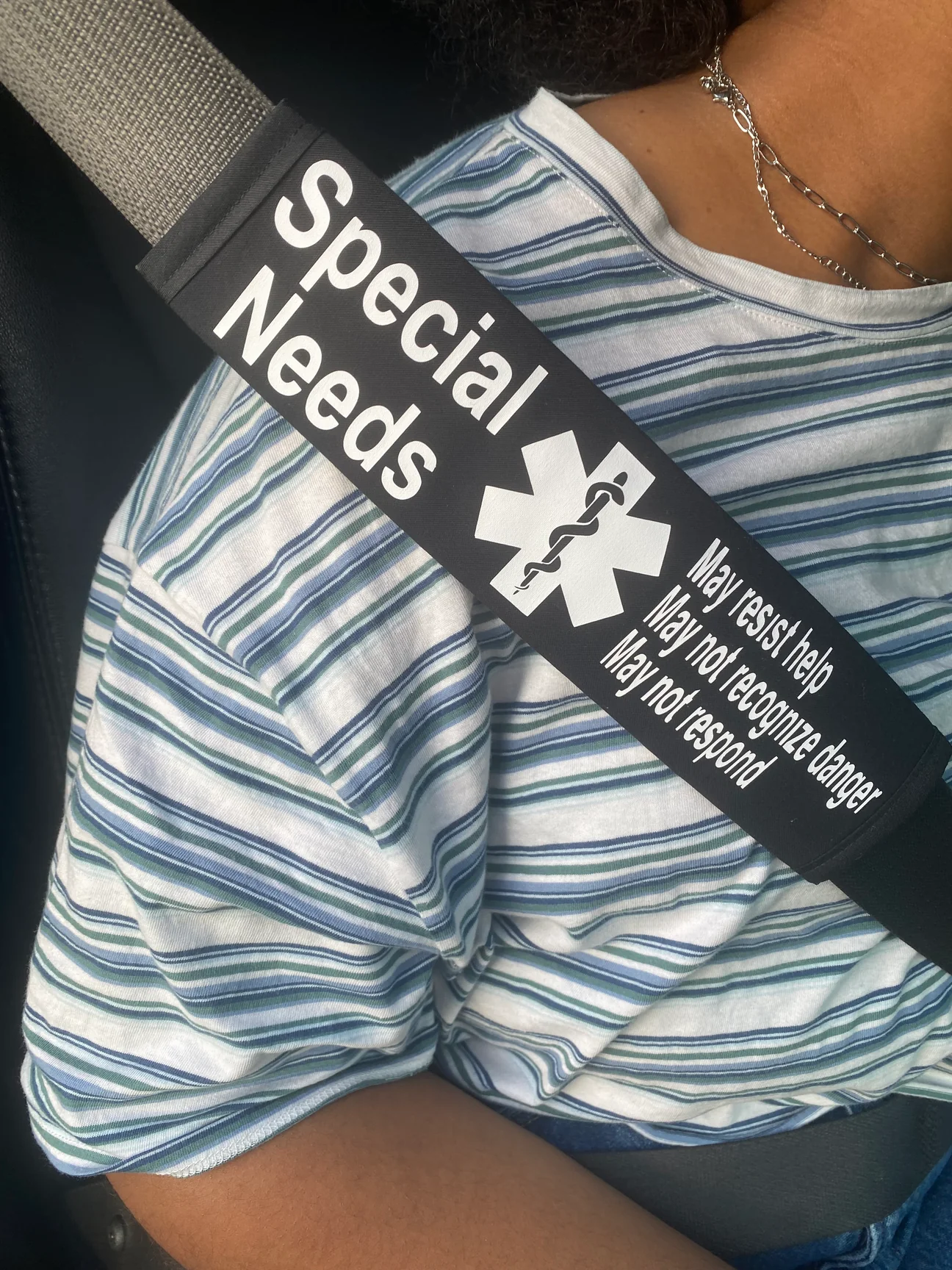 seat belt cover on a seat belt that says "special needs, may resist help, may not recognize danger, may not respond"