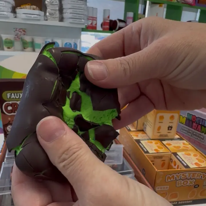 green squish toy with fake chocolate "shell" that is broken
