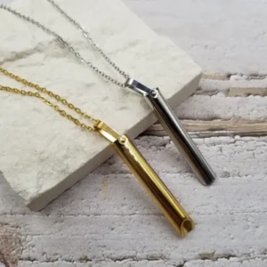 small tubular metal whistle on a chain, one silver, one gold