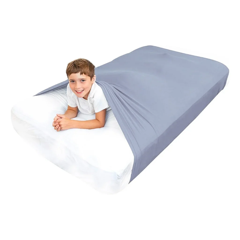 child on a mattress with a grey sheet that wraps around the entire mattress for compression