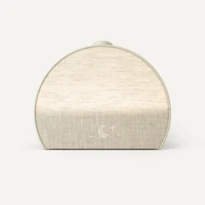 beige colored alarm clock is about 2/3 of a full circle shape with a fabric face