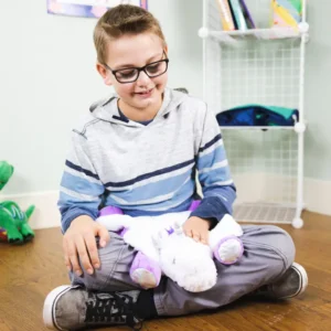 child sitting cross legged on the floor with a unicorn shaped white furry pad