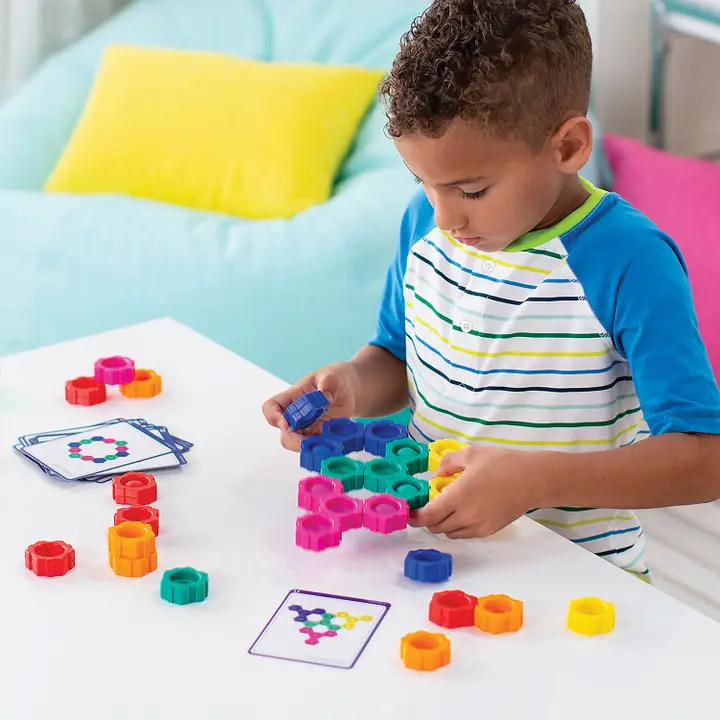 boy playing with hexagon shaped multicolored popper blocks with activity cards