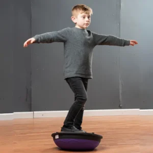child balancing with dome side down, arms stretched out at side