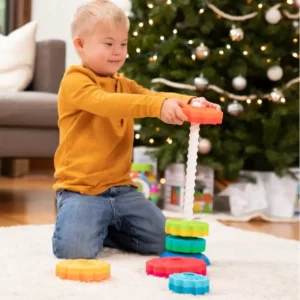 child by a christmas tree spinning a disc onto the white screw pole
