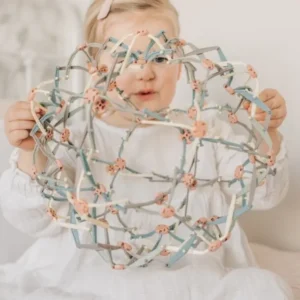 child holds expanded pastel colored ball