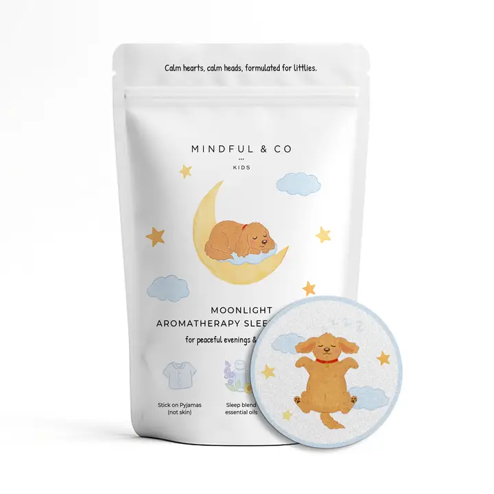White bag with dog sleeping on a crescent moon, with a round sticker with a dog sleeping among the clouds