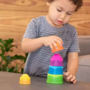 a small child stacks a 4th domed cup while the 5th sits on the table